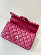 Chanel quilted flap bag open-top view, maroon-pink leather with gold clasp