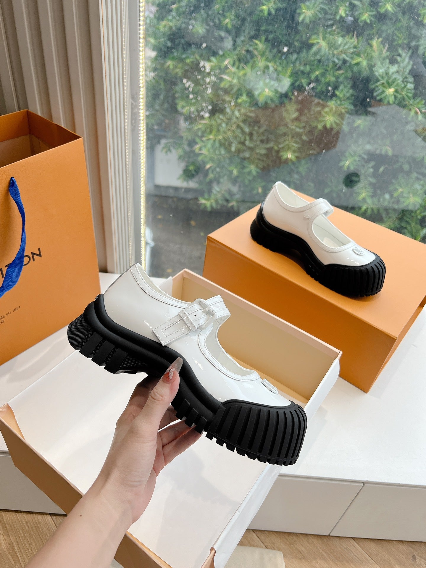 White and black Louis Vuitton unisex sneakers, side view with adjustable strap