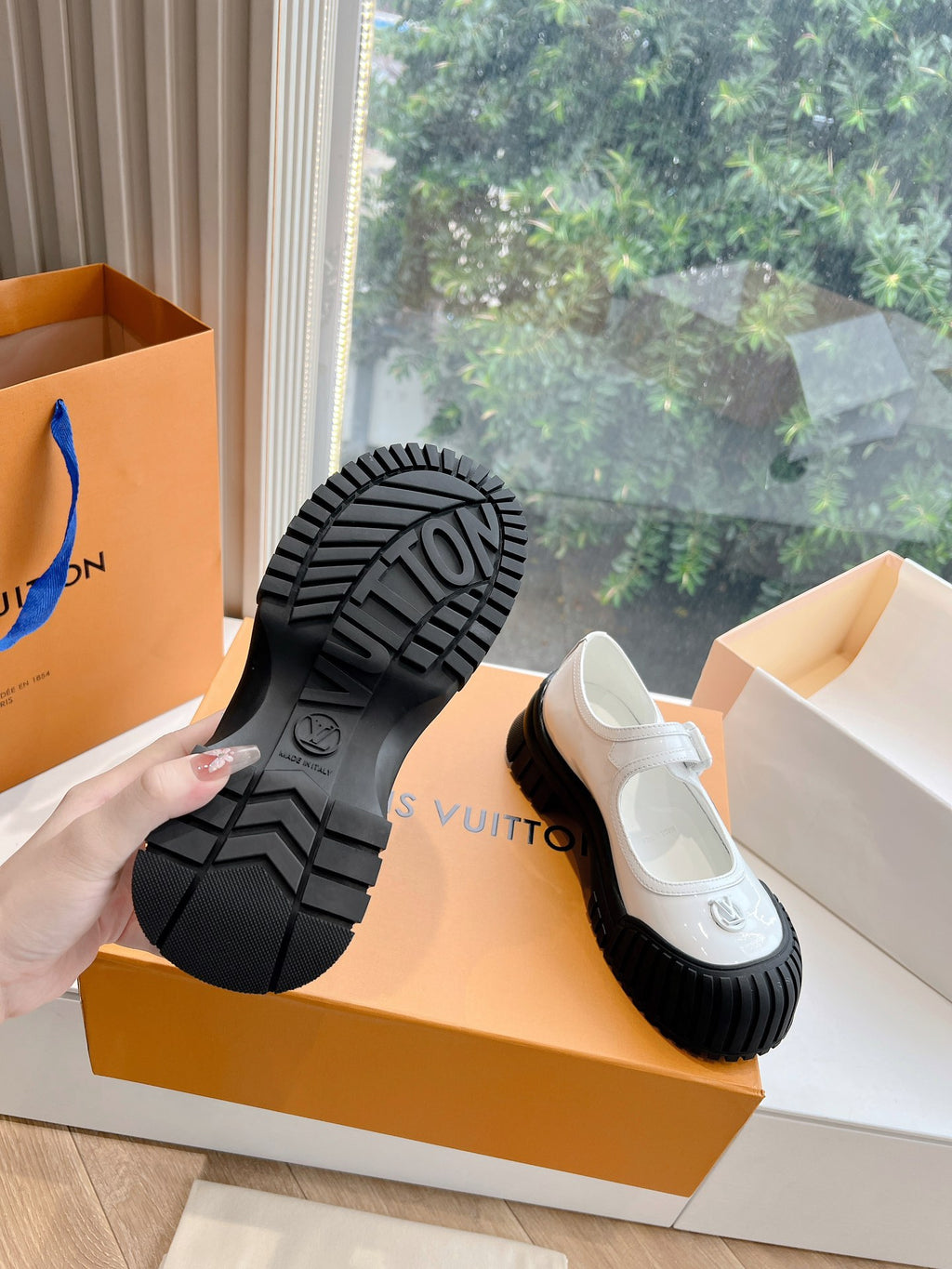 White and black Louis Vuitton unisex sneakers, outsole tread view with embossed logo