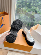 White and black Louis Vuitton unisex sneakers, outsole tread view with embossed logo