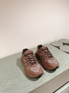 Unisex sneakers on display surface, tan uppers with brown tread soles