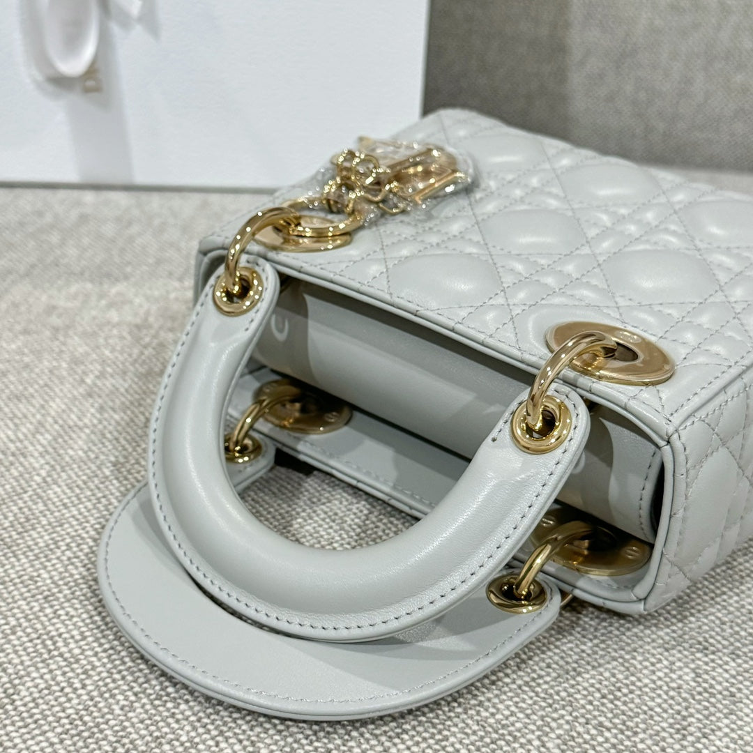 Dior bag open top: white quilted lining with gold-tone hardware and charm