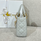 Dior quilted white shoulder bag with top handles and dangling charm tassel