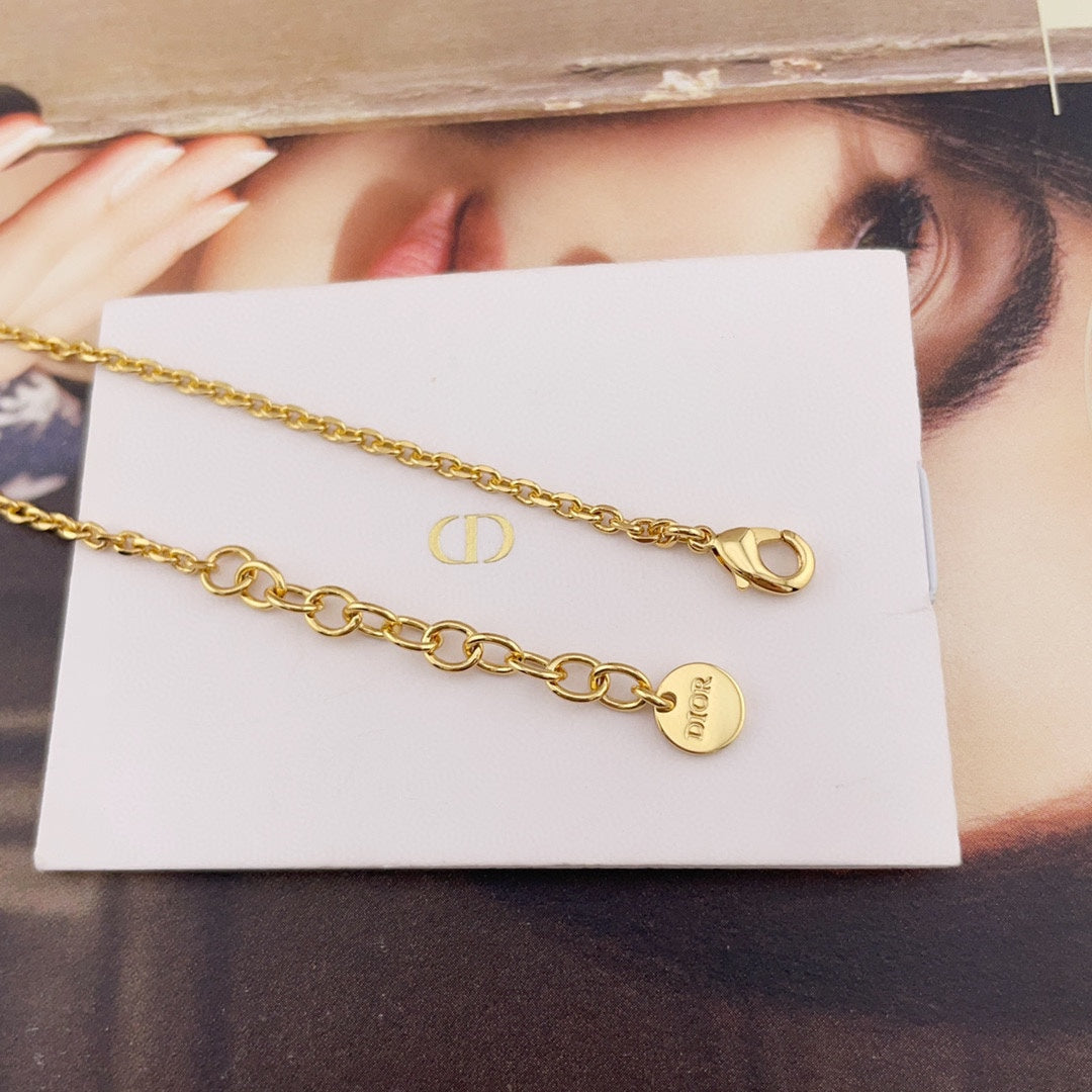 Gold chain necklace with Dior tag and round pearl charm