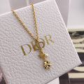 Gold charm necklace with star, flower, and pearl drop