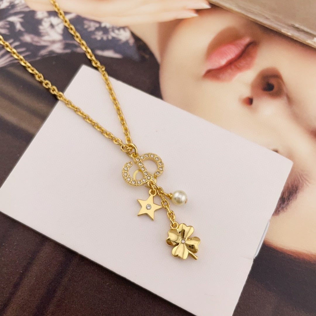 Gold charm necklace with interlocking ring, star, and pearl charms