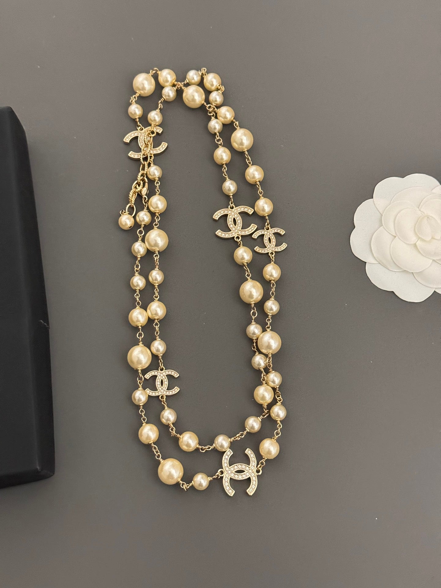 Gold-tone pearl lariat necklace with layered strands and Chanel CC logo charms