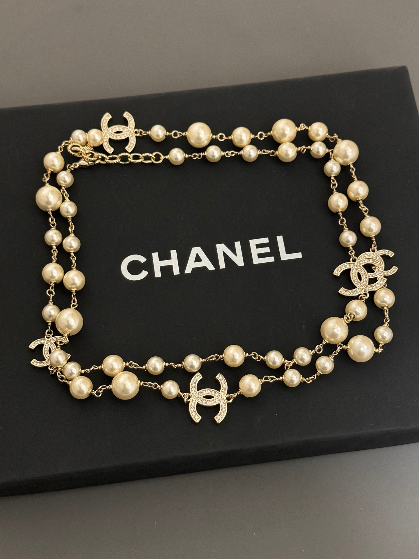 Gold-tone pearl necklace with Chanel logo charms and round bead stations