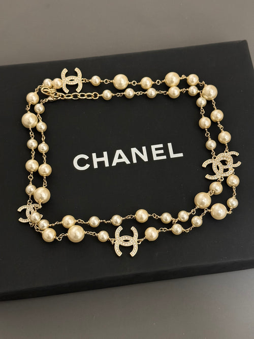 Gold-tone pearl necklace with Chanel logo charms and round bead stations