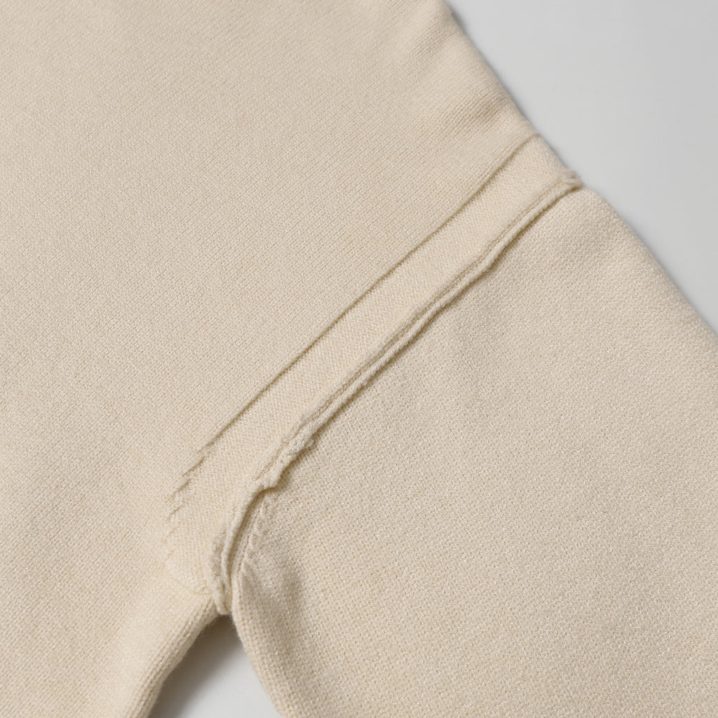 Light beige knit sweater seam detail on side of sleeve and body