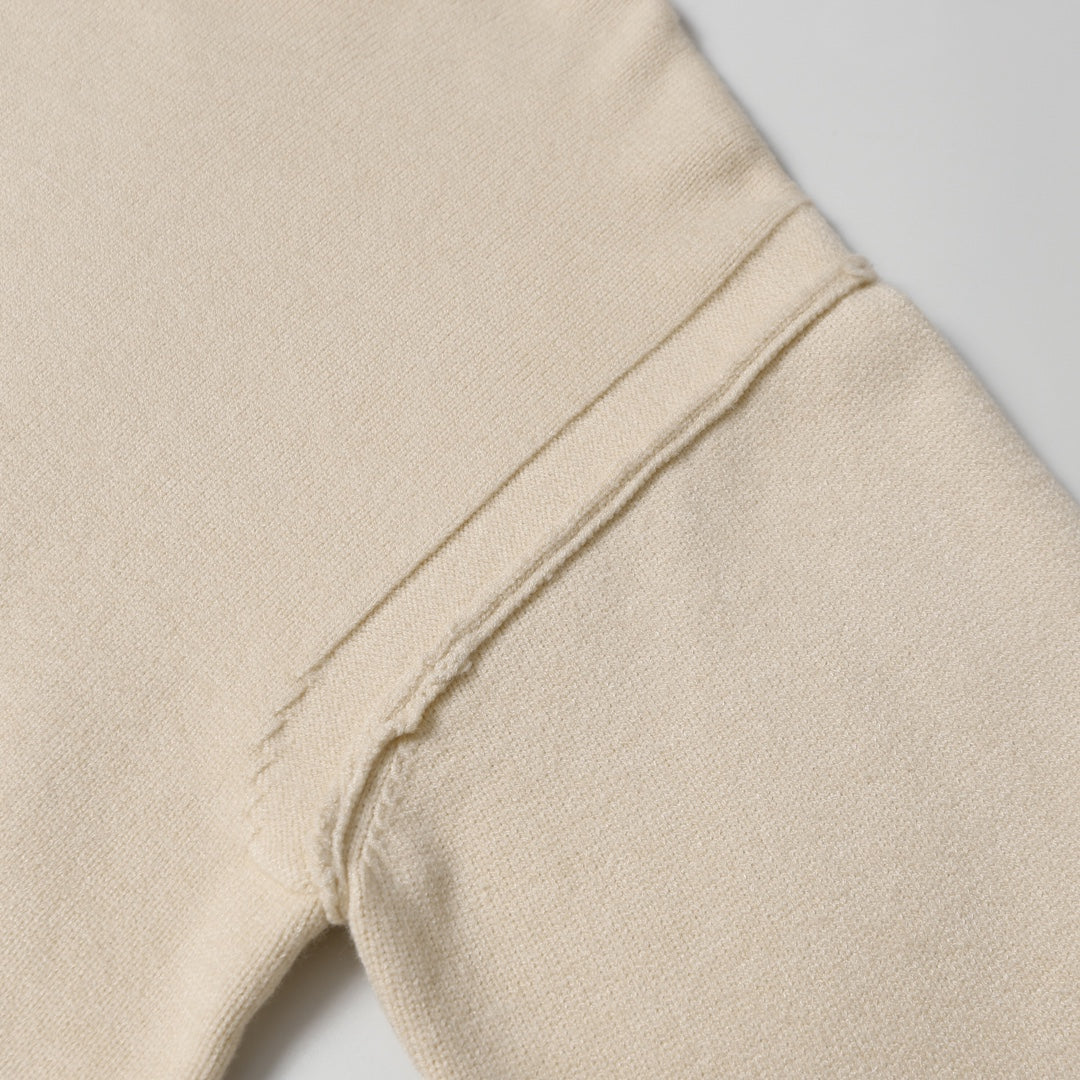 Light beige knit sweater seam detail on side of sleeve and body