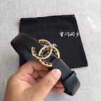 Black belt with gold CC logo buckle, held in hand over a pouch