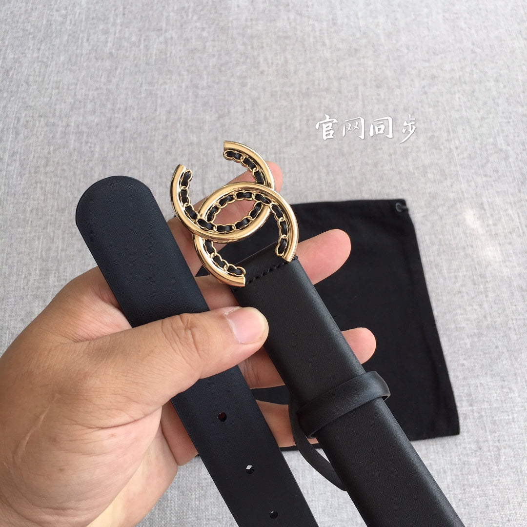 Black belt with gold CC medallion buckle, held with strap holes visible