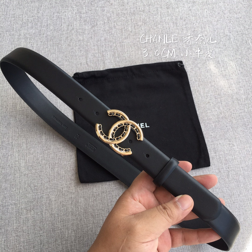 Black Chanel-style belt with gold CC buckle, shown laid across a pouch bag