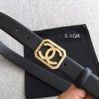 Dark leather Chanel belt with gold square logo buckle, rhinestone edging, and punched holes.