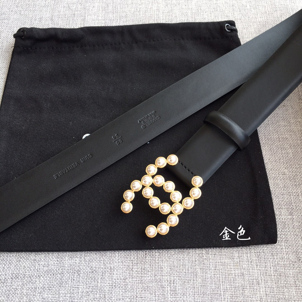 Black leather belt with faux pearl logo centerpiece and visible stitching edge.