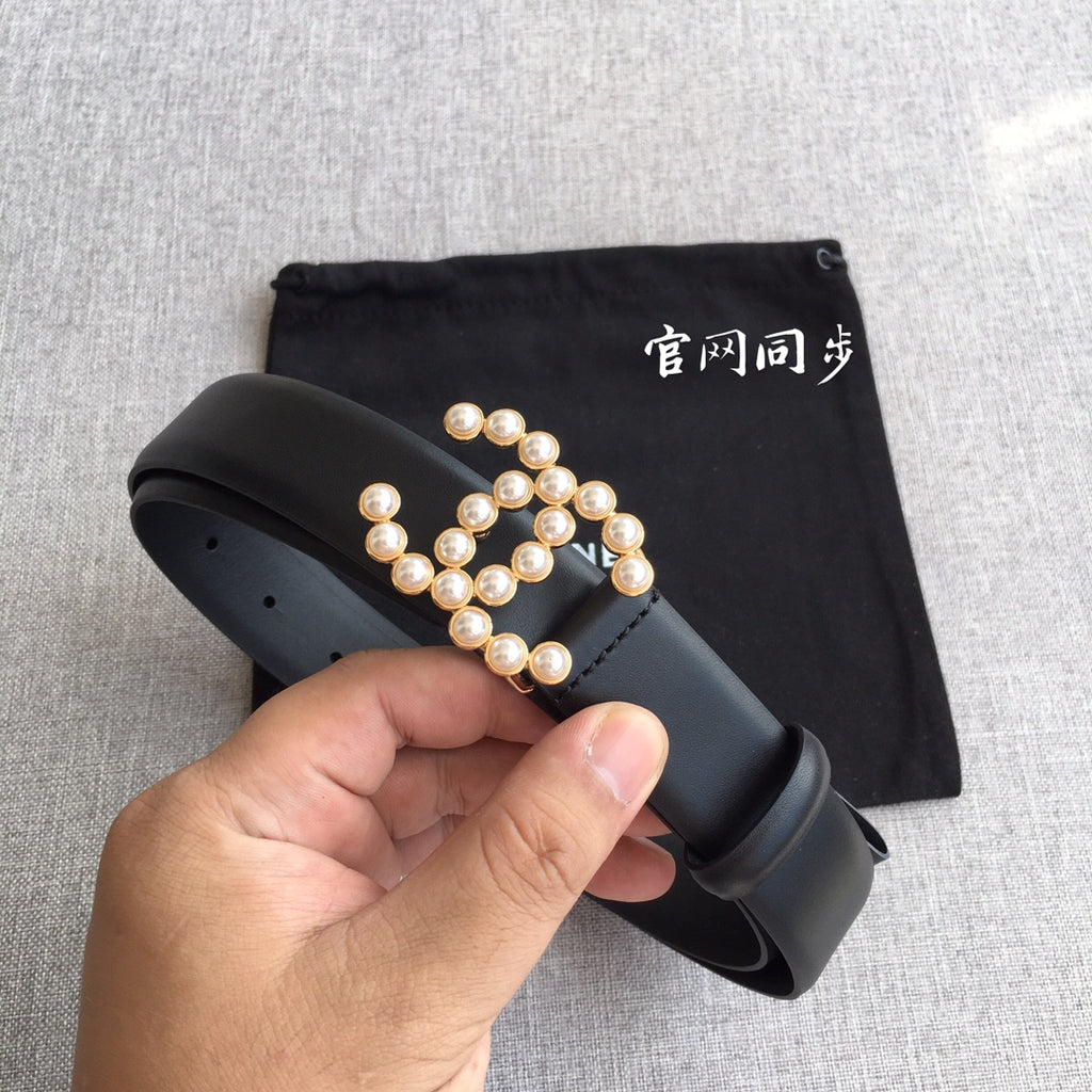 Black leather belt with faux pearl logo applique and matte finish buckle section.