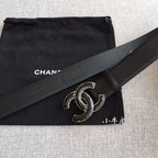 Dark leather belt with large gold-tone interlocking C buckle and stitched strap keeper.