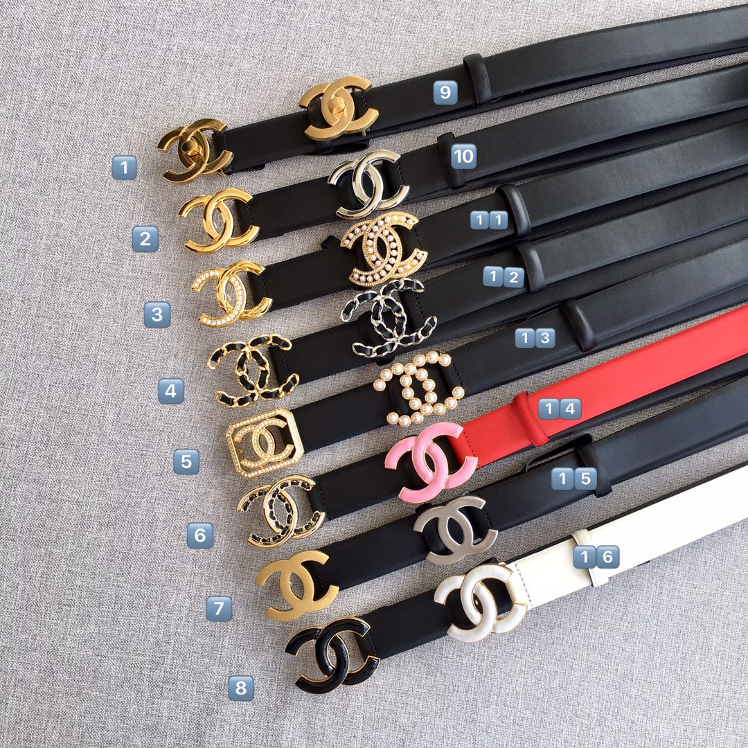 Assorted designer-style belts with various gold and enamel logo buckles