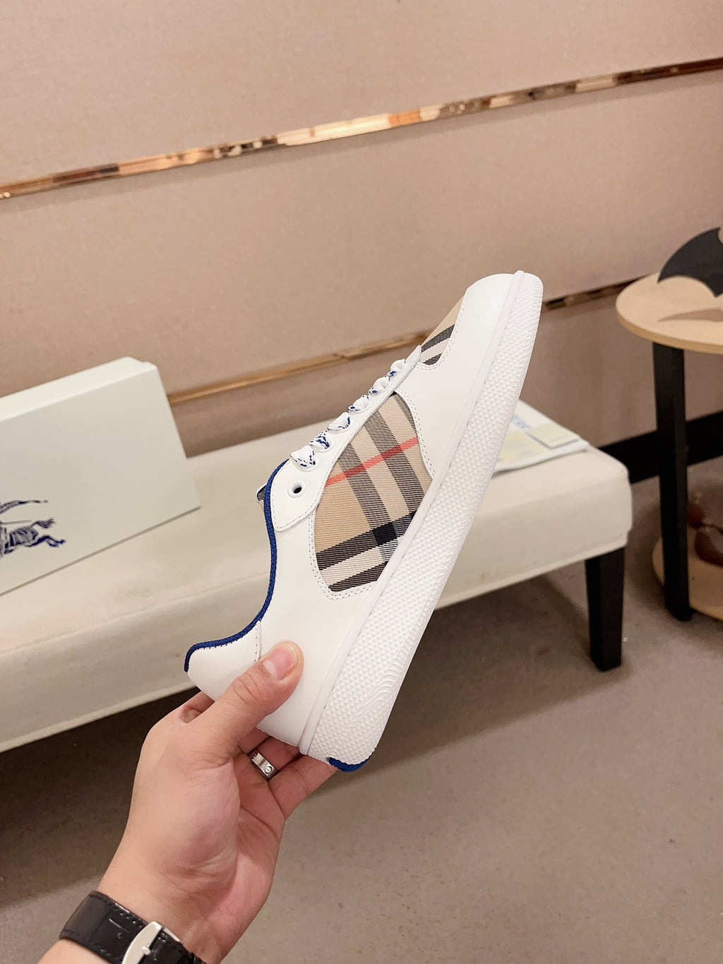 Burberry white sneaker side view with blue collar lining and lace-up eyelets