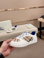 Burberry white sneaker with plaid strap panel, blue heel, and textured rubber sole