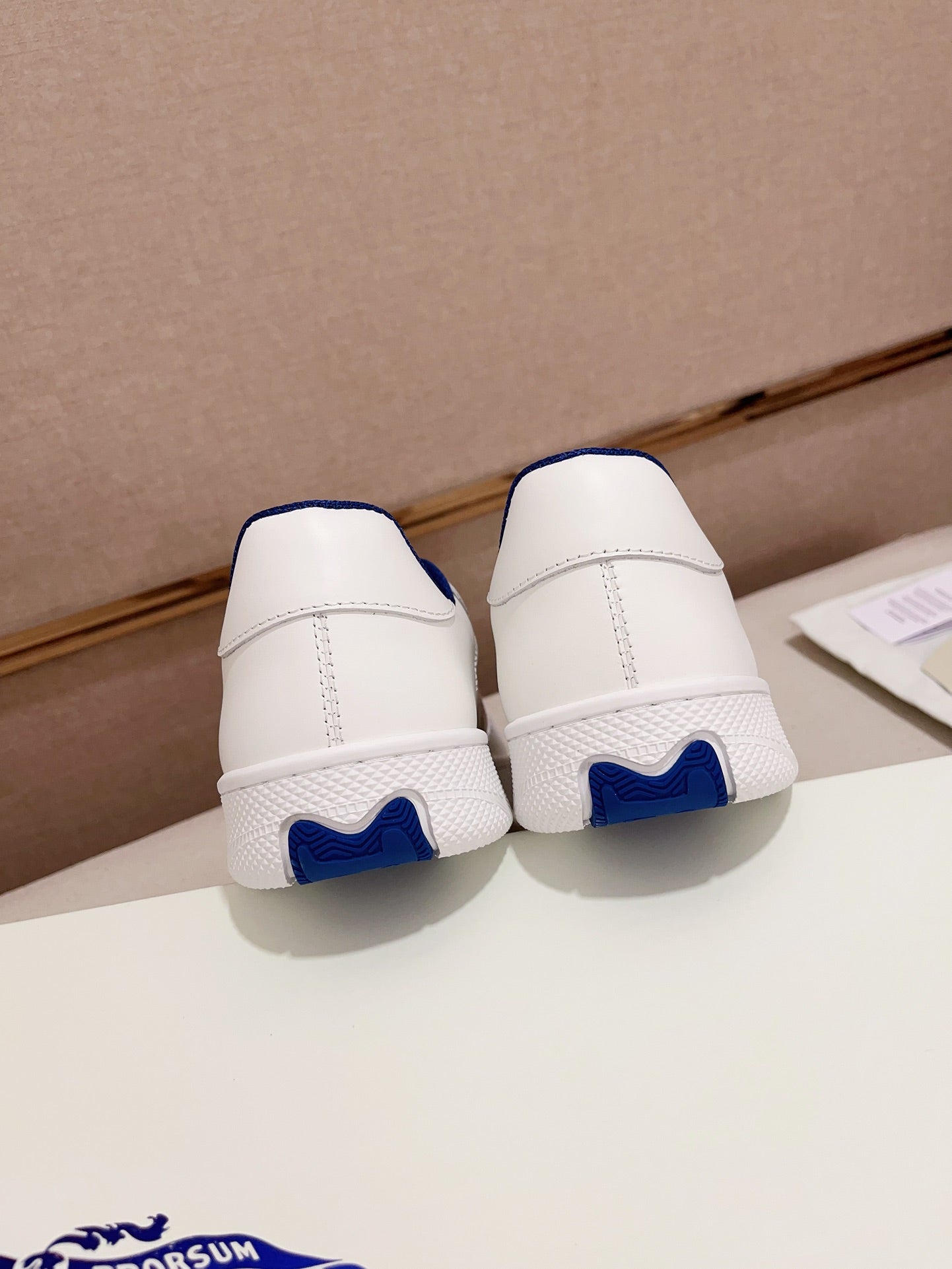 Burberry white sneakers back view with blue heel trim and cushioned sole
