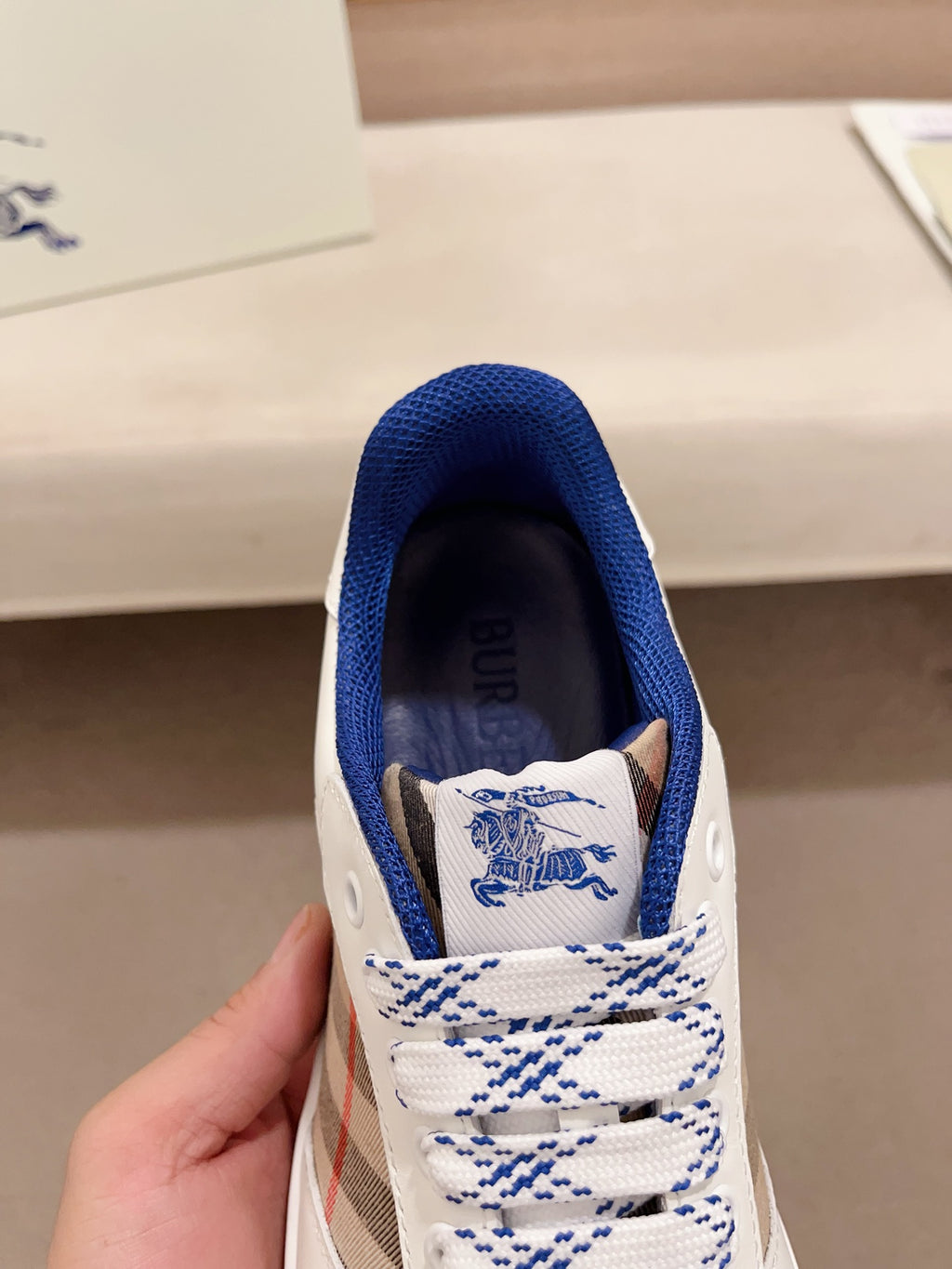 Burberry sneaker tongue and interior lining with blue logo and white lace-up panel
