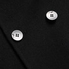 Black overcoat detail: round metal buttons on front placket