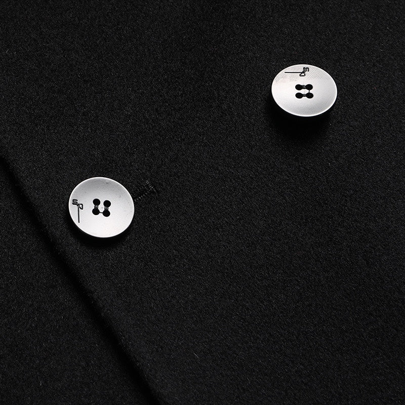 Black overcoat detail: round metal buttons on front placket