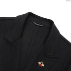 Black overcoat lapel with small embroidered logo pin