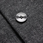 Charcoal coat front button detail with four-hole design