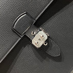 Hermes bag clasp close-up with silver-toned lock plate and round hardware studs.