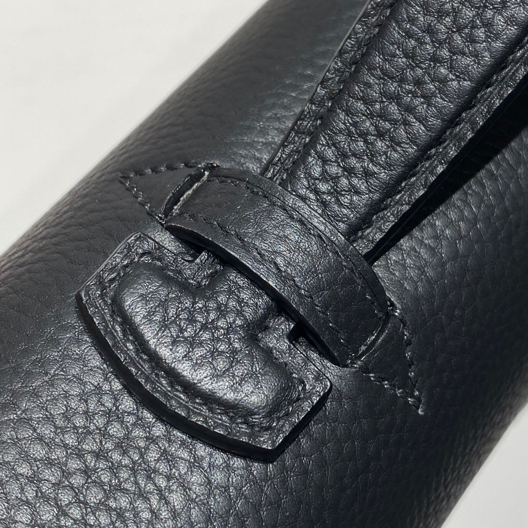 Hermes bag leather close-up with stitched strap keeper and metal buckle detail.