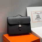 Hermes bag in dark leather with flap closure and metal lock clasp, shown front view.