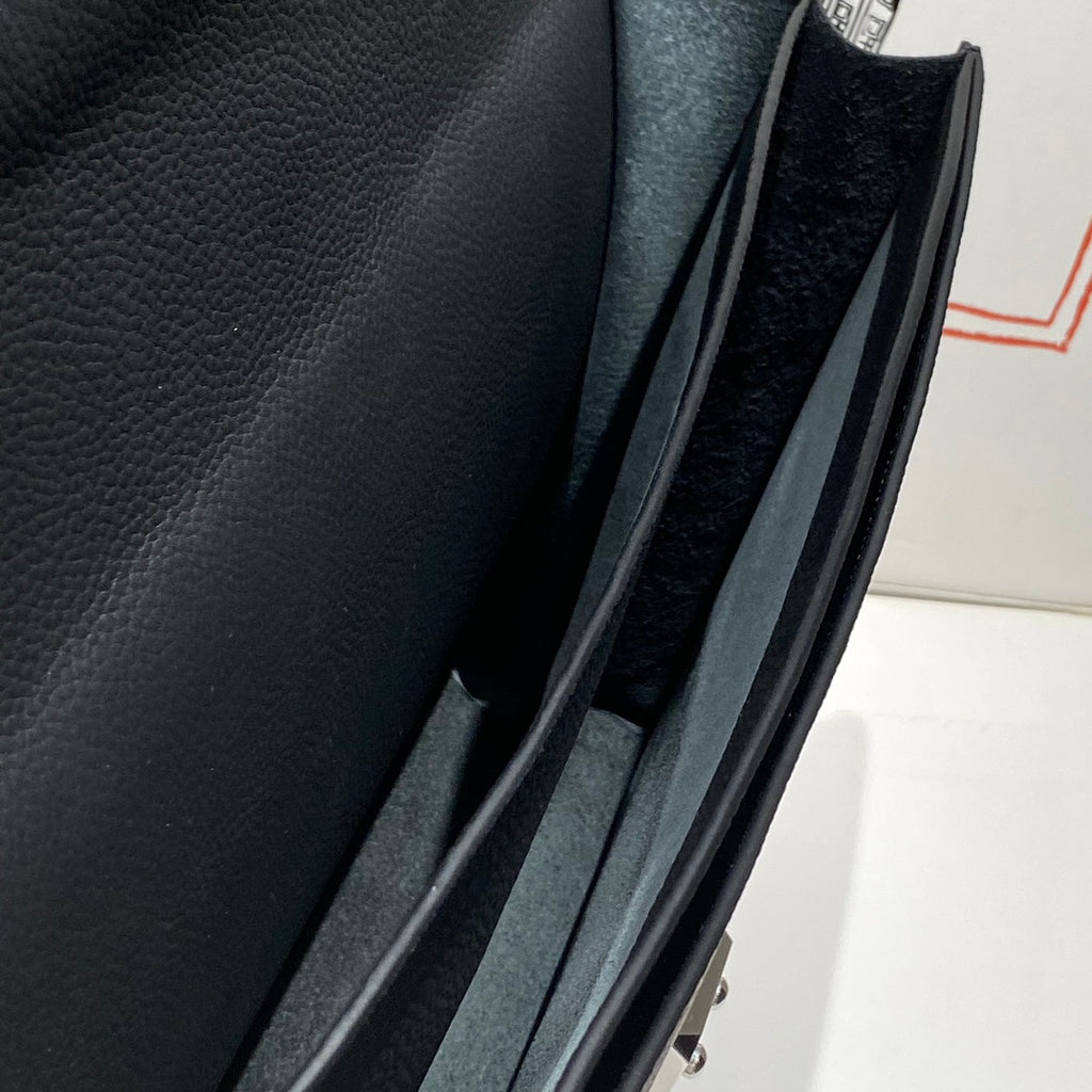 Hermes bag interior close-up with dark lining and attached strap inside the frame.