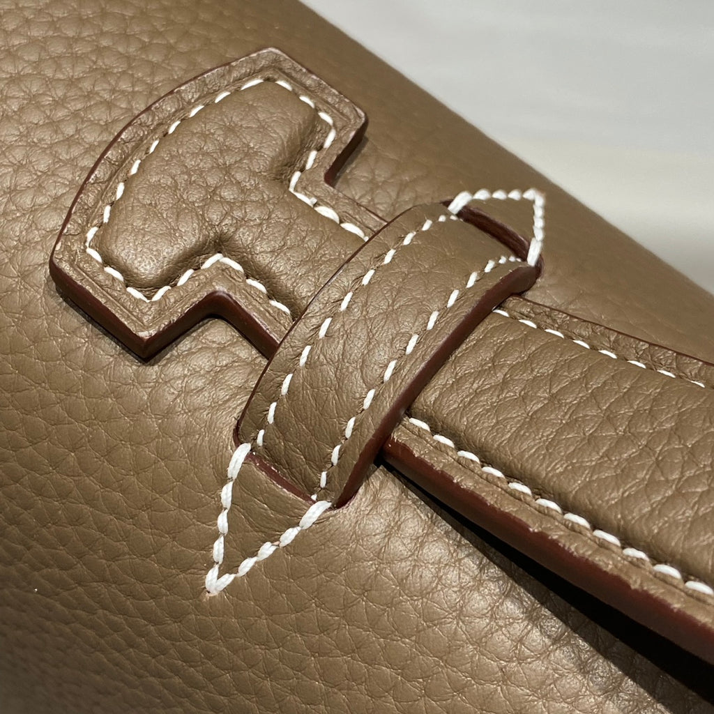 Hermes leather flap closure with stitched tongue and embossed H detail