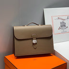 Hermes structured leather handbag with front flap, top handle, and lock clasp
