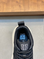 Black sneakers with blue logo lining on tongue and lace-up front