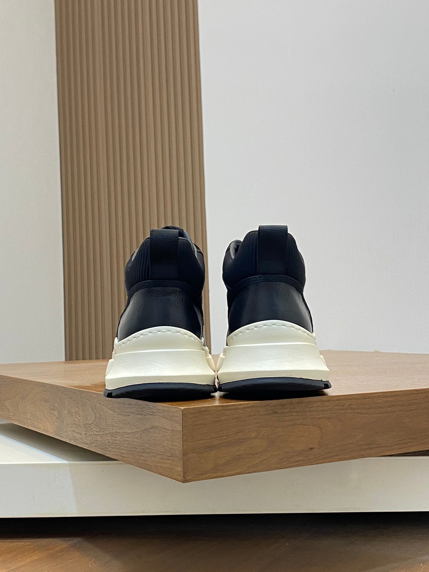 Black and white sneakers, back view with padded heel and thick sole