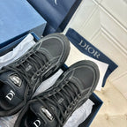 Dior unisex sneakers close-up, dark grey uppers with laces and logo detail on tongue