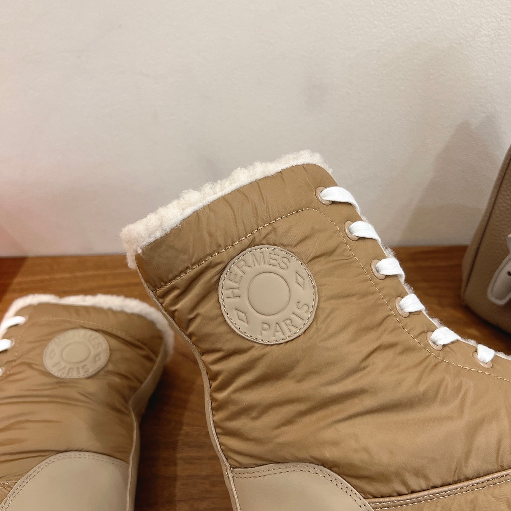 Hermes unisex boot upper detail with circular logo patch, white laces, tan shearling trim.