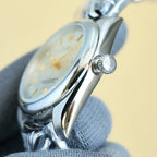 Rolex wristwatch side view with crown and curved polished steel case