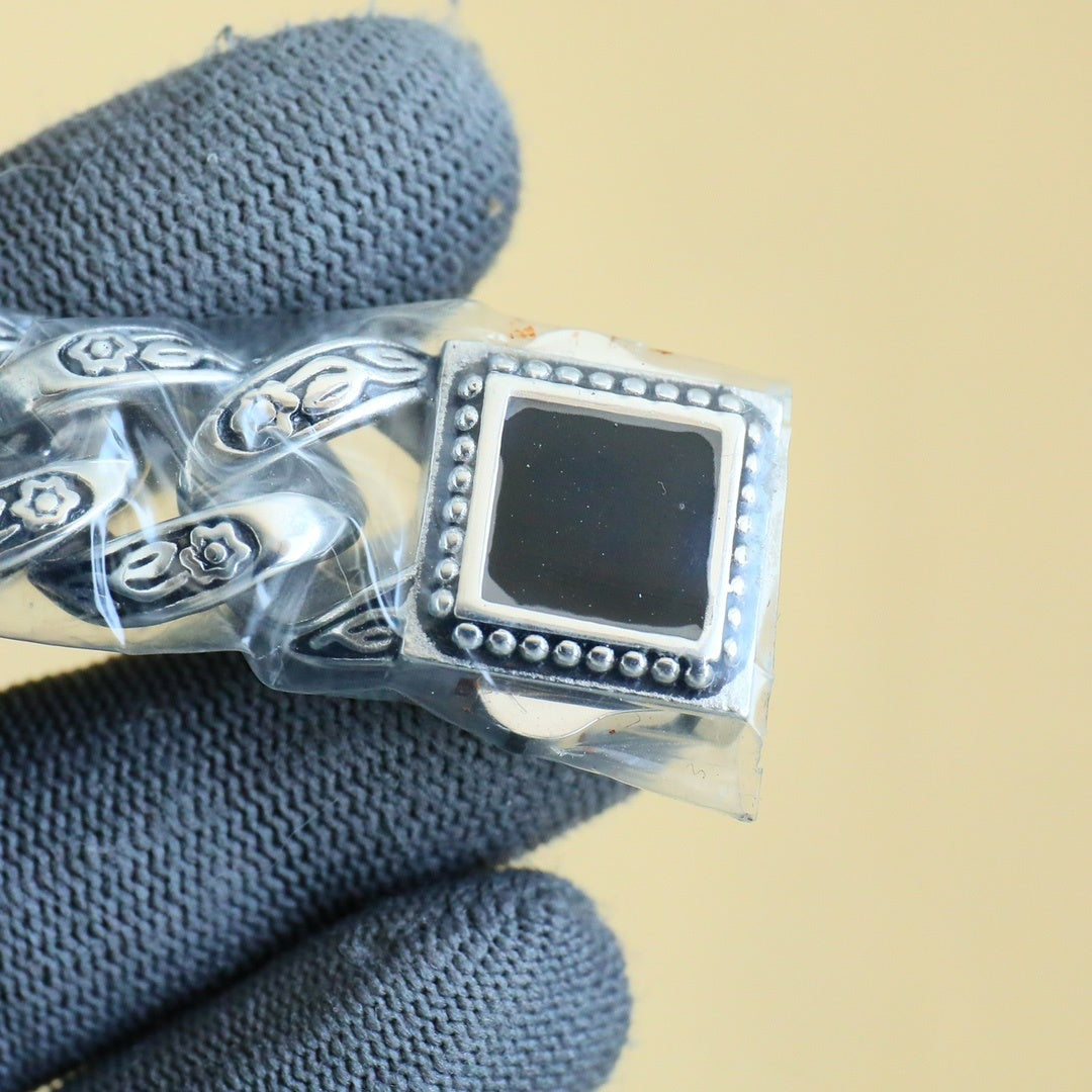 Rolex watch caseback detail with engraved metal and a small rectangular dark window
