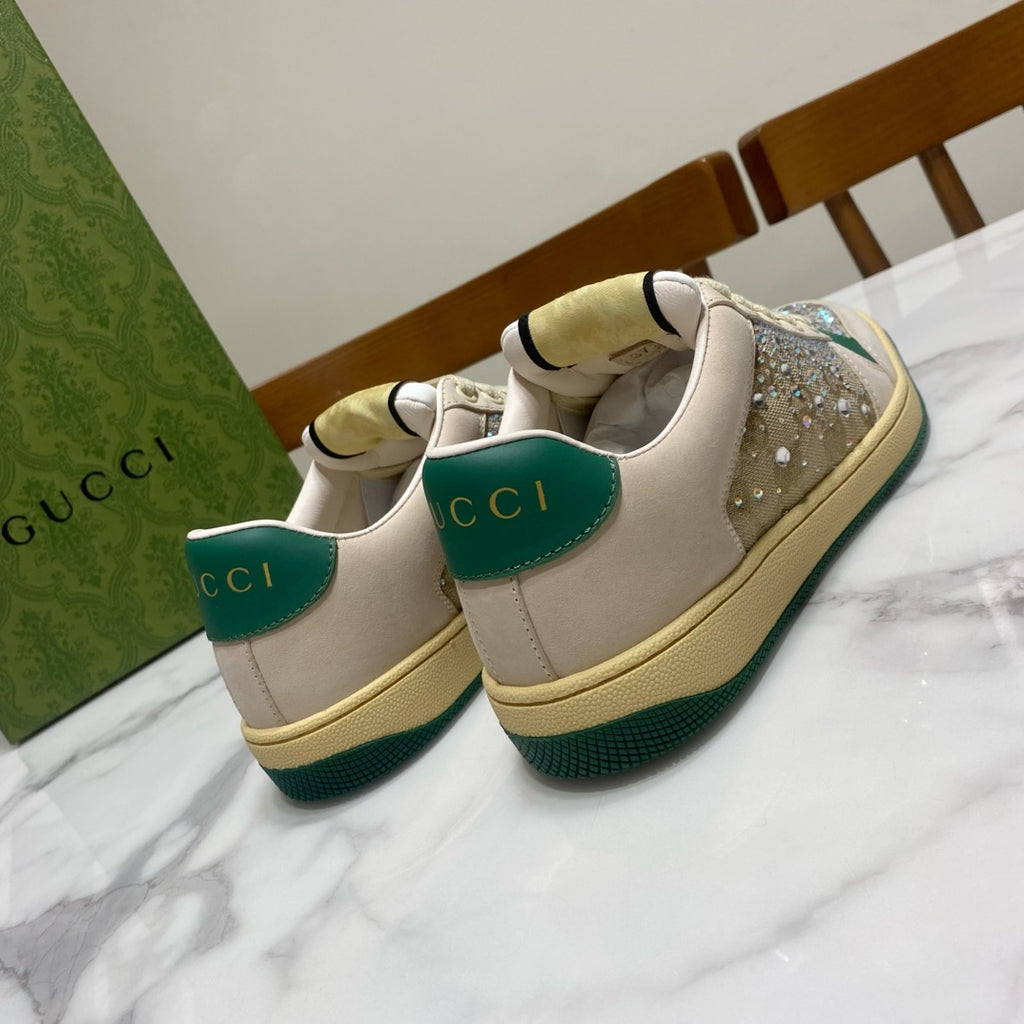 Gucci sneakers with cream uppers, green heel tabs, and rhinestone sparkle on the toe