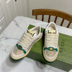 Gucci sneakers pair on a green box: cream uppers with green panels and glitter accents