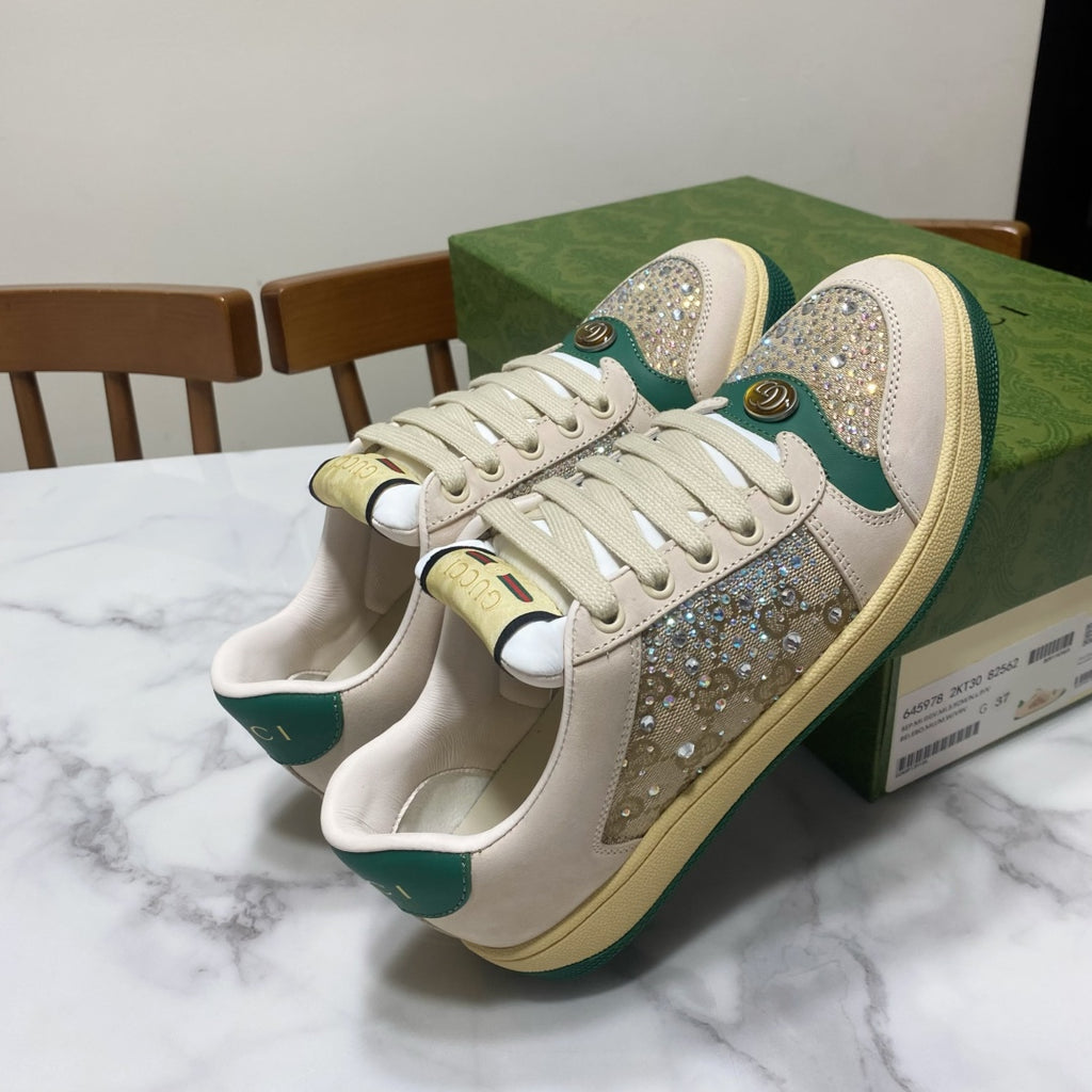 Gucci unisex sneakers pair shown at an angle: cream uppers with green accents and glitter