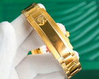 Gold-tone watch bracelet and case side with crown on a white glove