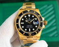 Rolex Submariner watch with black dial and gold-tone link bracelet