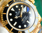 Rolex Submariner watch close-up, black dial with gold indices and date window