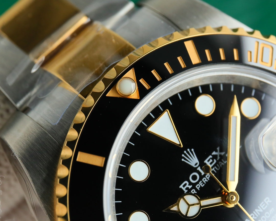 Rolex watch close-up of bezel and crown area, black dial with gold hour markers